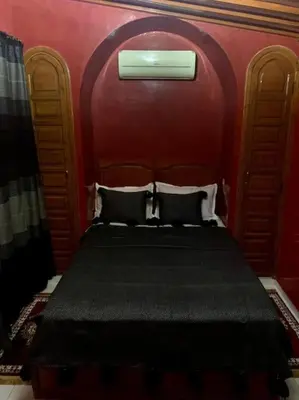 a bedroom with a bed with a red wall at Riad Sofia in Marrakech