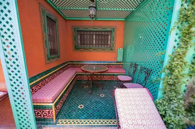 a room with pink chairs and a table in a room at Riad Sofia in Marrakech