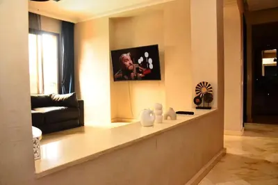 a living room with a couch and a picture on the wall at Oasis aux Palmeraies à Marrakech in Marrakech