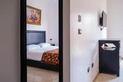 a mirror in a room with a bed in a room at Hotel Apart HLB in Marrakech