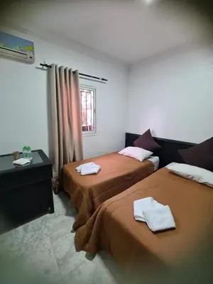 a hotel room with two beds and a window at Hotel Apart HLB in Marrakech
