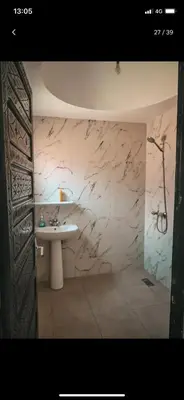a bathroom with a sink and a marble wall at Riad with swimming pool in Marrakech