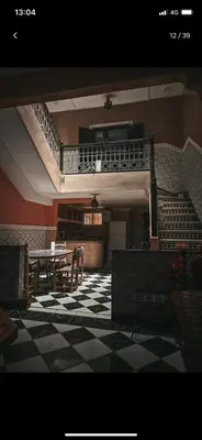 a room with a checkered floor and a table and stairs at Riad with swimming pool in Marrakech