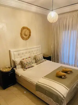a bedroom with a large white bed with a window at Cosy Appartement Centre Gueliz avec piscine in Marrakech