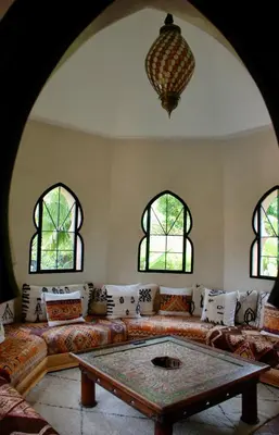 a living room with a couch and two windows at Dar Anacaona in Marrakech
