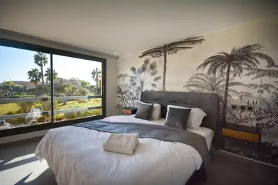 a bedroom with a large bed with a large window at Duplexe Luxueux de 2 Suites in Marrakech
