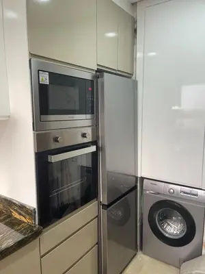 a kitchen with a microwave and a washing machine at Prestigia 2 chambres vue piscine agate in Marrakech