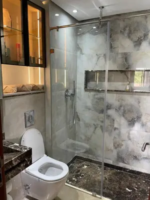 a bathroom with a toilet and a glass shower at Prestigia 2 chambres vue piscine agate in Marrakech