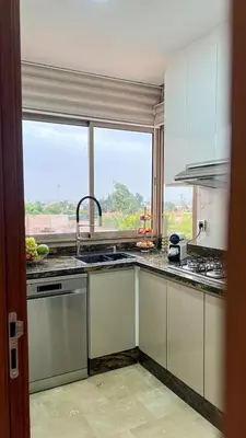a kitchen with a sink and a window at Prestigia 2 chambres vue piscine agate in Marrakech