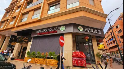 a man standing in front of a store on a street at Cyndi Home Gueliz \u72ec\u4eab\u6574\u5957\u516c\u5bd3 in Marrakech