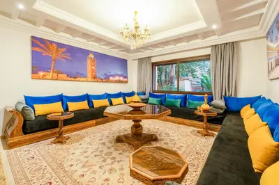 a living room with blue couches and a chandelier at Amazing apartment in the heart of Marrakesh in Marrakech