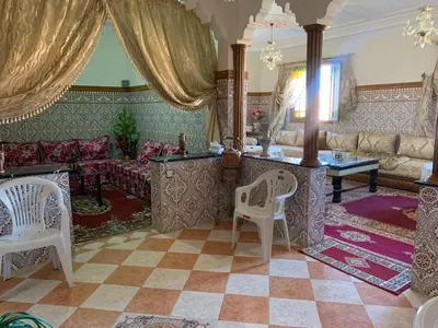 a living room with a couch and a table and chairs at Apparemment Aglmous in Marrakech