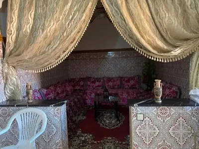 a living room with a couch and curtains at Apparemment Aglmous in Marrakech