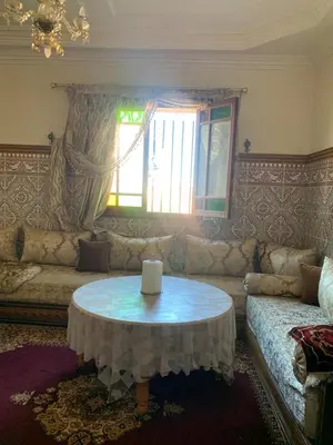 a living room with a table and a couch at Apparemment Aglmous in Marrakech