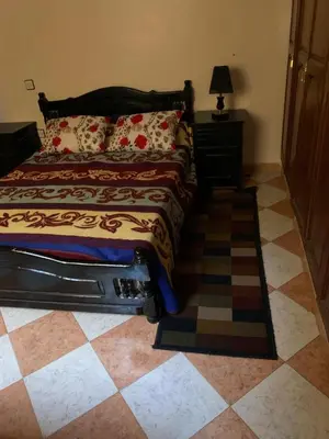a bedroom with a bed and a checkered floor at Apparemment Aglmous in Marrakech