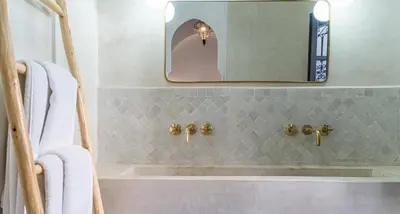 a bathroom with a bath tub and a mirror at Riad COPAH in Marrakech