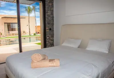 a bedroom with a bed with a towel on it at Villa Palmeraie 4 suites zéro vis à vis in Marrakech