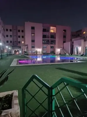 a large building with a swimming pool at night at Ruime 2 kamer appartement 5 min van het centrum in Marrakech