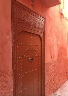 a brown door in the side of a red building at Riad Charij in Marrakech