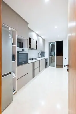 a large kitchen with white cabinets and appliances at Chic 2 Bedroom with Mountain views Gueliz in Marrakech