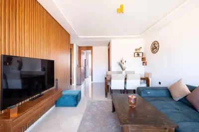 a living room with a blue couch and a tv at Chic 2 Bedroom with Mountain views Gueliz in Marrakech