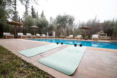 a swimming pool with two surfboards in front of it at La Villa Safran Ailleurs sous les Oliviers in Marrakech