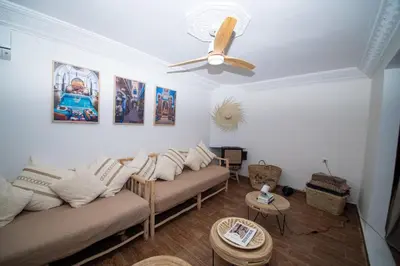 a living room with a couch and a ceiling fan at La Villa Safran Ailleurs sous les Oliviers in Marrakech