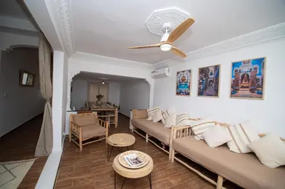 a living room with couches and a ceiling fan at La Villa Safran Ailleurs sous les Oliviers in Marrakech