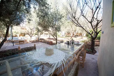 a glass table with a hat on top of it at La Villa Safran Ailleurs sous les Oliviers in Marrakech