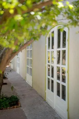 a building with a white door and a sidewalk at La Villa Safran Ailleurs sous les Oliviers in Marrakech