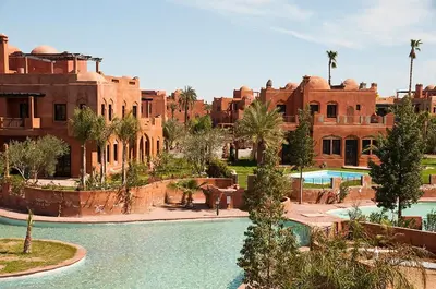 a resort with a pool in front of a building at Palacio Hôtel Condominium Marrakech in Marrakech