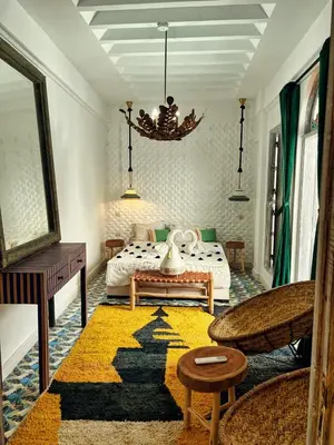 a living room with a bed and a rug at Riad dar darcom in Marrakech