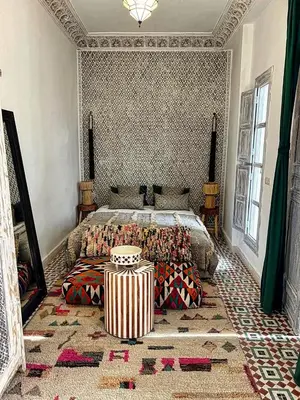 a bedroom with a bed with pillows on it at Riad dar darcom in Marrakech