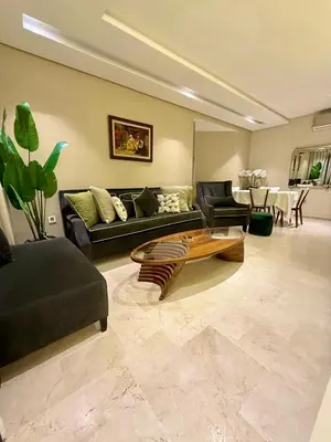 a living room with a couch and a coffee table at Prestigia Marrakech golf city appartement 3 chambre in Marrakech