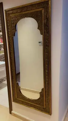 a mirror with a wooden frame on a wall at HOURIA LOC Marrakech in Marrakech