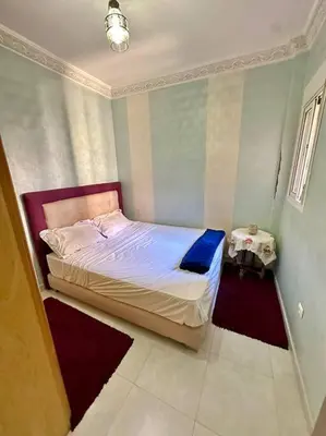 a small bedroom with a bed and a table at 2B Flat City Center Marrakech in Marrakech