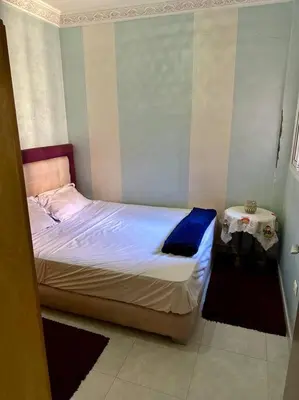 a small bedroom with a bed and a table at 2B Flat City Center Marrakech in Marrakech