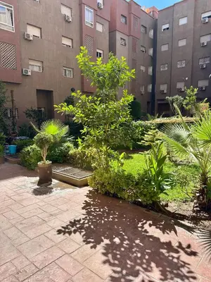 a courtyard with trees and plants in front of a building at 2B Flat City Center Marrakech in Marrakech