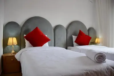 two beds with red pillows in a bedroom at apart in the centre of marrakech gueliz in Marrakech