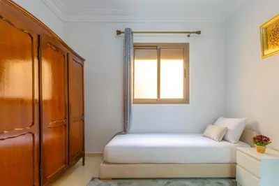 a bedroom with a bed and a window at Jardins d'Anas Appartement Airport in Marrakech