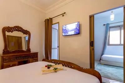a room with a bed and a mirror and a mirror at Jardins d'Anas Appartement Airport in Marrakech