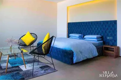 a bedroom with a blue bed and two chairs at Magnifique villa sur front de golf Amelkis in Marrakech