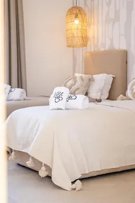 a bedroom with two beds with white sheets and pillows at Villa 150 Amelkis 2-piscine chauffée in Marrakech