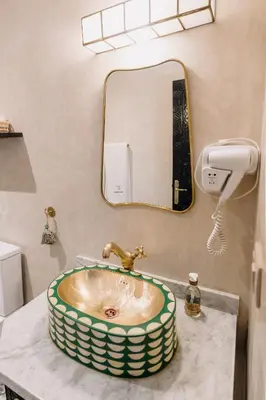 a bathroom with a sink and a mirror at Riad Cologne in Marrakech