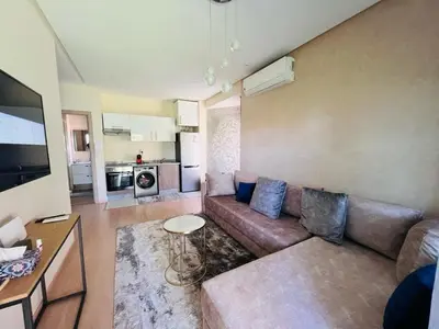 a living room with a couch and a table at Luxueux Prestigia golf city Marrakech in Marrakech