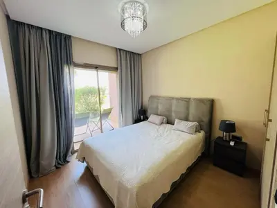 a bedroom with a bed and a large window at Luxueux Prestigia golf city Marrakech in Marrakech