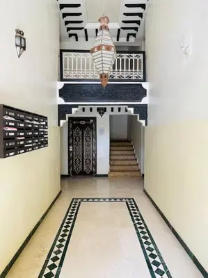 a hallway with stairs and a chandelier in a building at Confort et Style Studio Chic avec Piscine in Marrakech