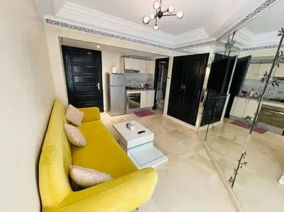 a living room with a yellow couch and a table at Confort et Style Studio Chic avec Piscine in Marrakech