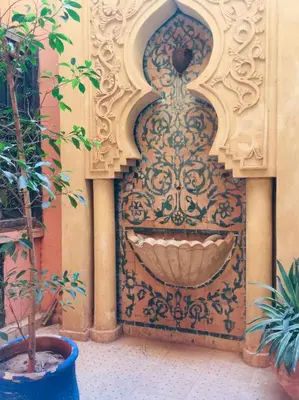 a water fountain in the side of a building at Riad Oued Issil in Marrakech