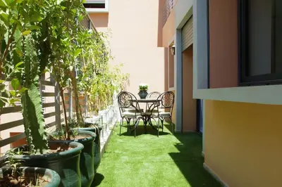 a balcony with a table and chairs and potted plants at Elegant and Modern appart hôtel with Best location in Marrakech